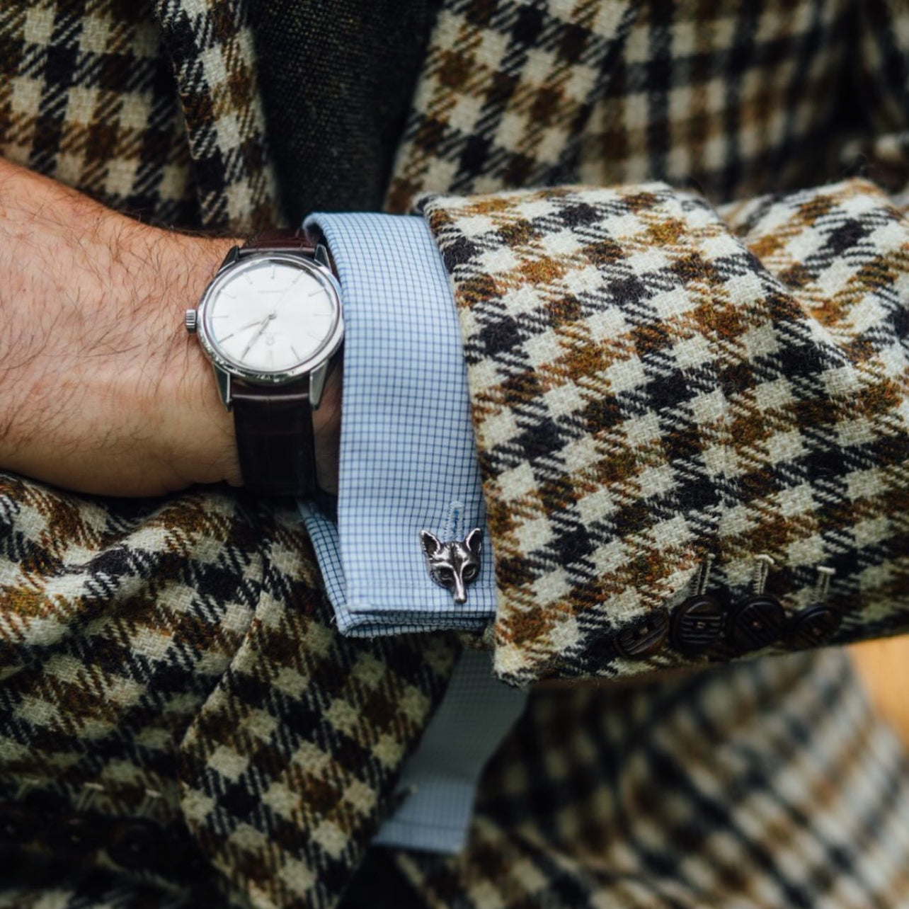 Close view of Fox Mask cufflinks styled with Fox Brothers tweed tailoring